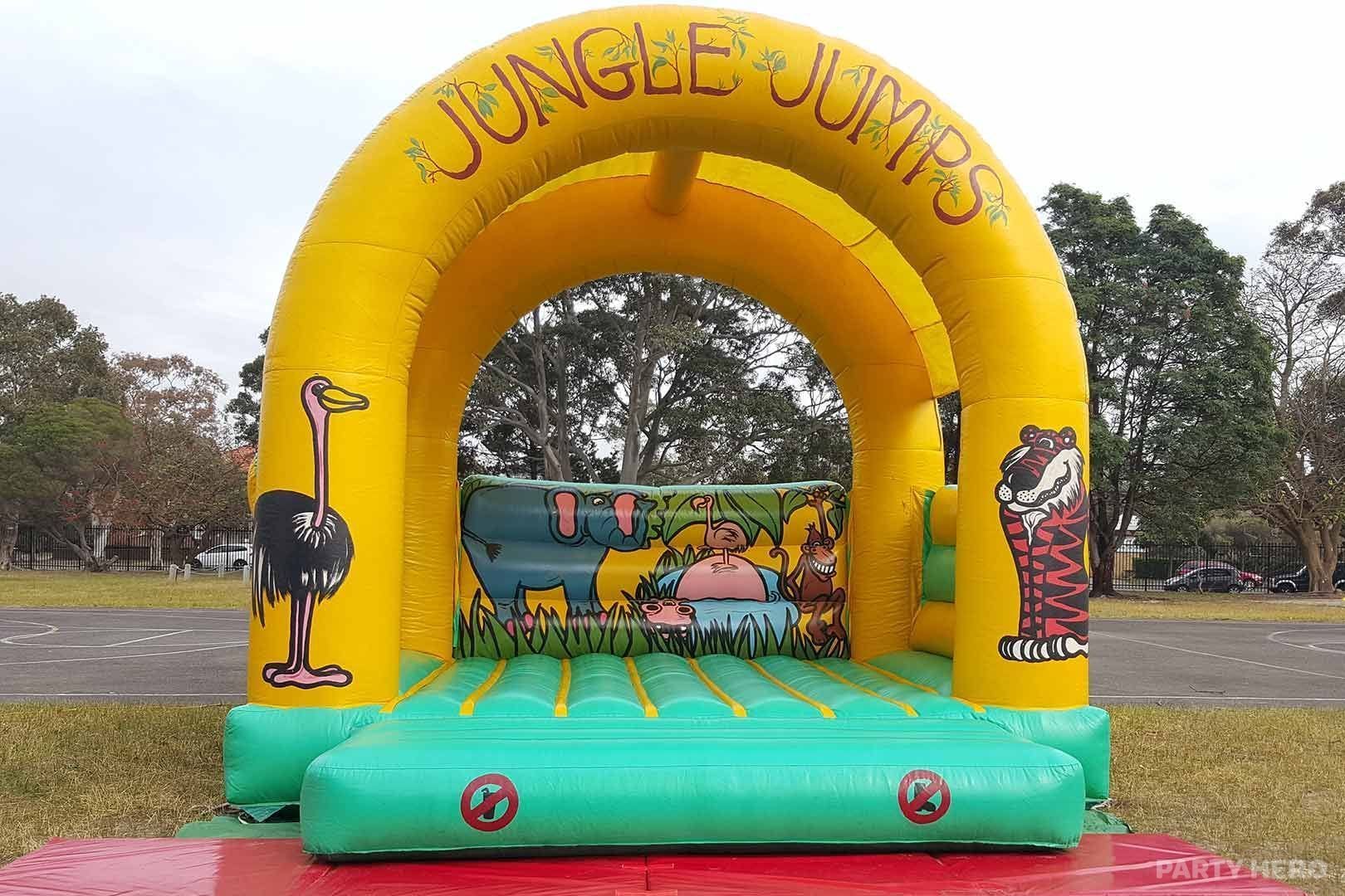 Jungle Jumps castle with a yellow arch and animal artwork in a schoolyard
