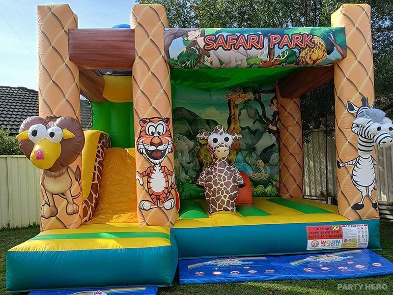 Safari Park castle with a slide and cartoon lion, giraffe and zebra cut-outs in a backyard