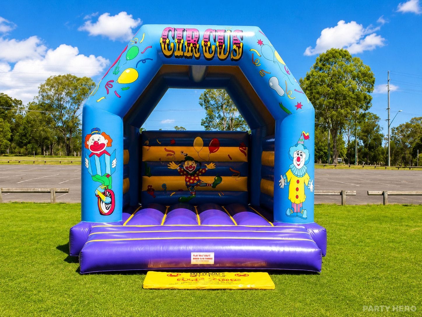 Jumping castle hire in Sydney — clown-themed midi castle with an open bouncing floor, set up in a park