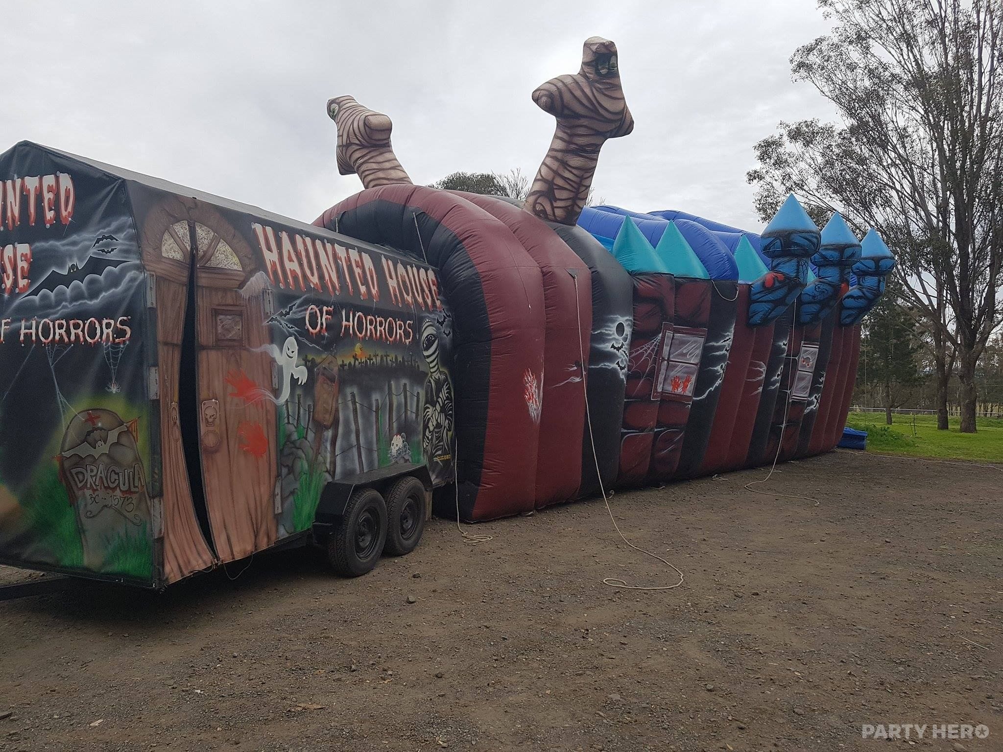 Haunted Fun House walk-through inflatable with painted trailer entrance, inflated on a paddock in south-west Sydney