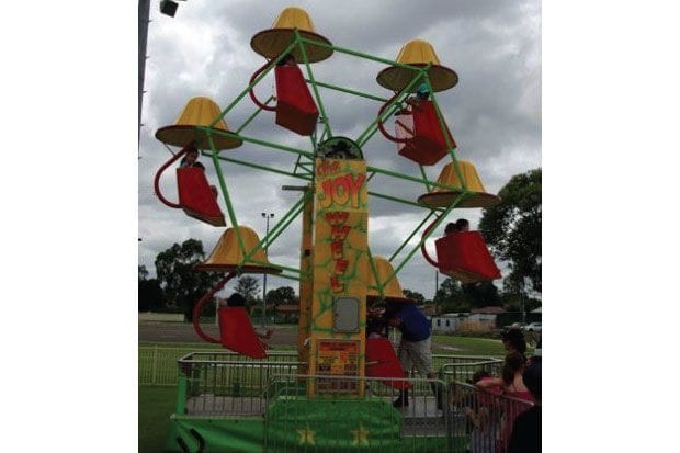 Mini Ferris wheel with six covered seats for young children at a community fair