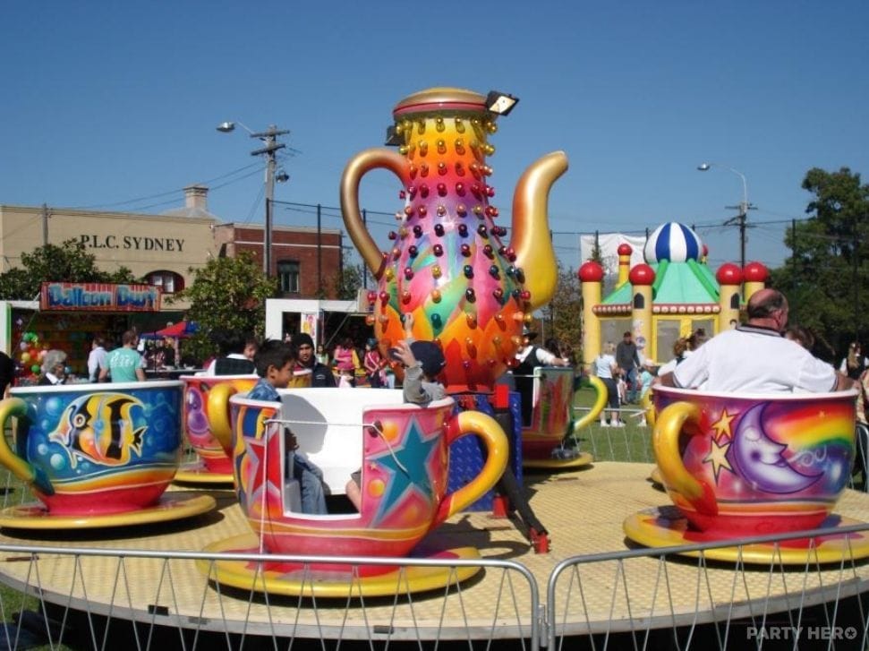 Teacup ride with a giant teapot centrepiece spinning riders at an outdoor school fete