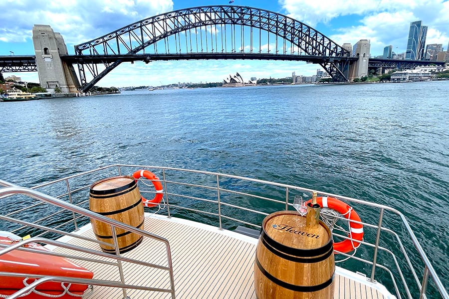 Wine barrels styled as tables on the aft deck with the Harbour Bridge and Opera House in the background