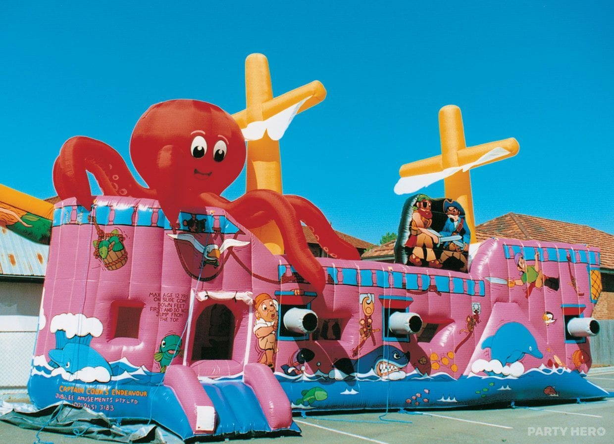 Pink pirate ship inflatable with an octopus on top at a school fete