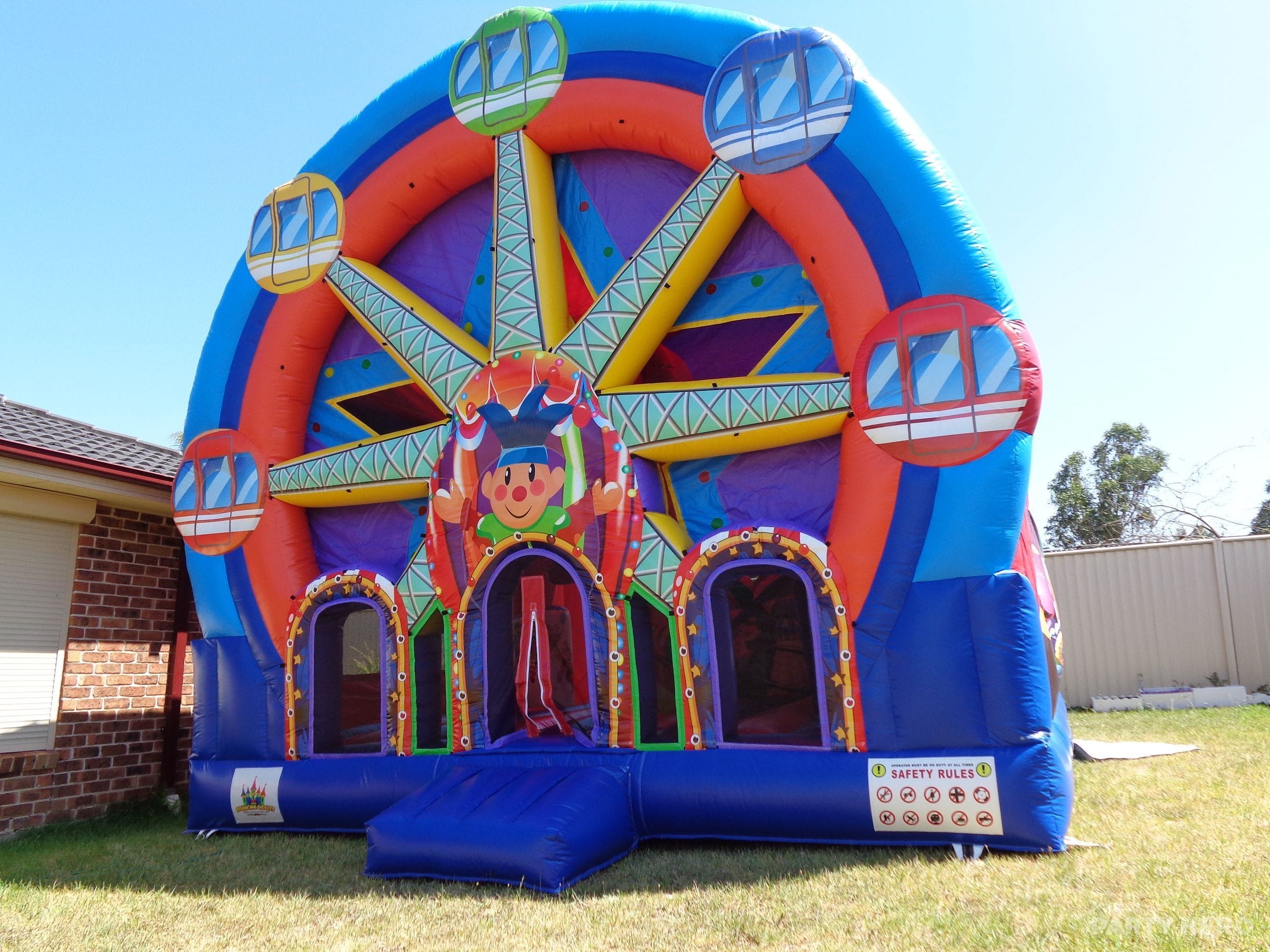 Ferris wheel themed jumping castle inflated on a backyard lawn