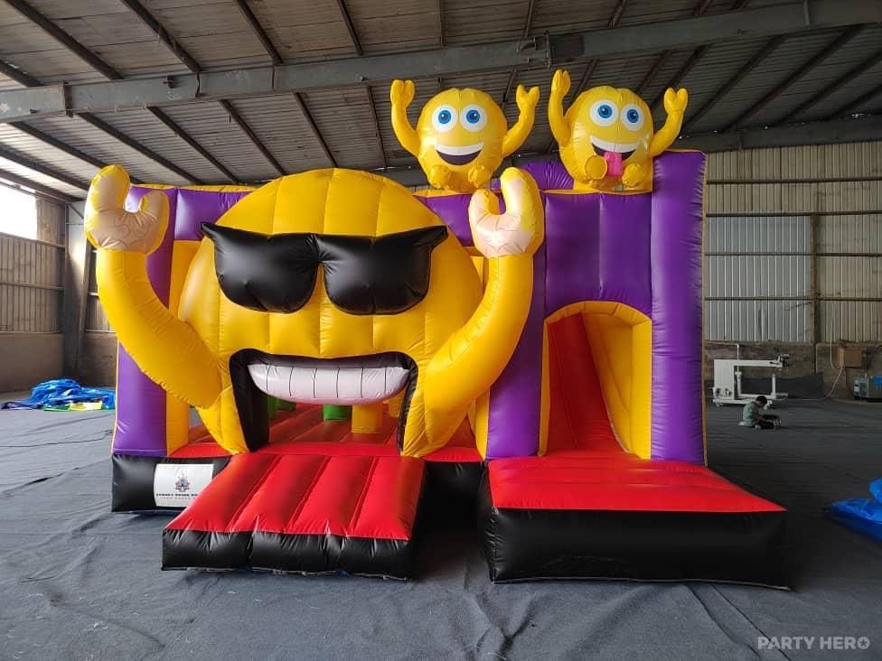 Yellow emoji jumping castle with sunglasses face on the front