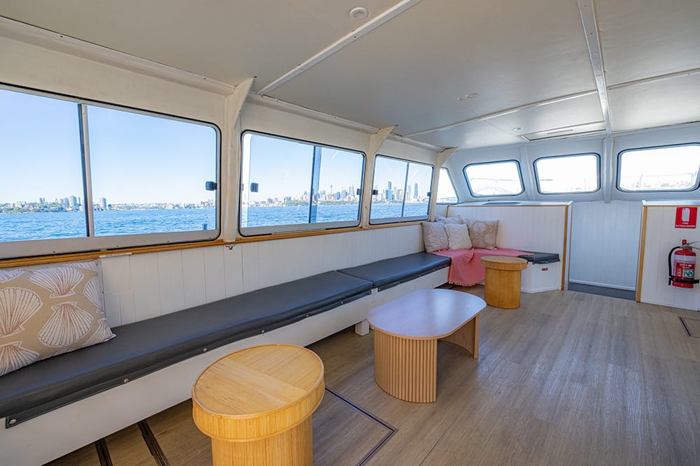 Ali B's lower deck seating with the Sydney skyline visible through the windows